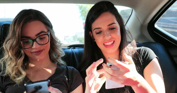 Candid Friends Holding Cellphones Back Seat Taxi Authentic Girlfriends Looking — Fotografia de Stock