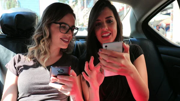 Friends Looking Cellphones Back Seat Taxi Cab Gossiping Browsing Internet — Stockfoto