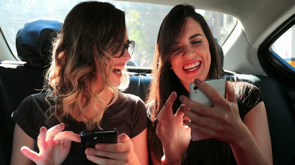 Женщины Подруги Просматривают Свои Смартфоны Время Езды Такси Смеясь Женщины — стоковое фото