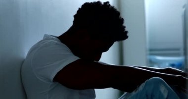 Person sitting on floor with mental illness