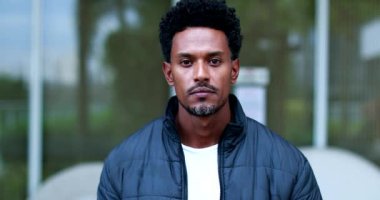 Confident black person walking towards camera in slow-motion
