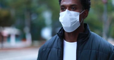 Person wearing surgical face mask outbreak prevention while walking in city outside