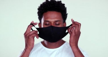 African person removing mask feeling relief