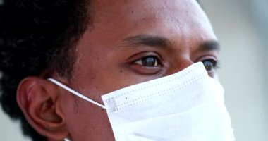 Close-up black man face wearing covid-19 mask, african person coronavirus