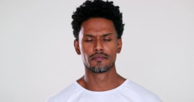 Judgemental black african man listening looking to camera changing mood becoming serious