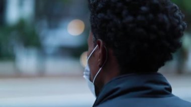 Black man wearing pollution mask in city environment