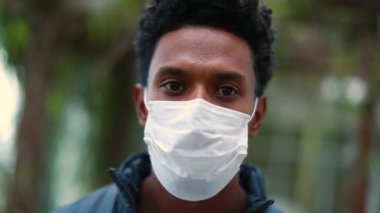 African man removing covid-19 mask, end of pandemic. Black person removes disease mask