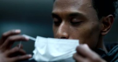 African black man putting on covid virus mask looking at mirror