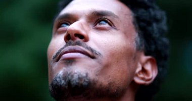 Hopeful man of african descent turning head to the sky feeling faithful and spiritual
