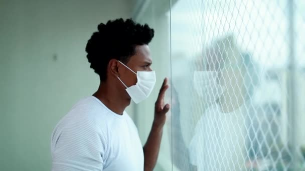 African Man Wearing Covid Mask Standing Window Looking Out City — Video