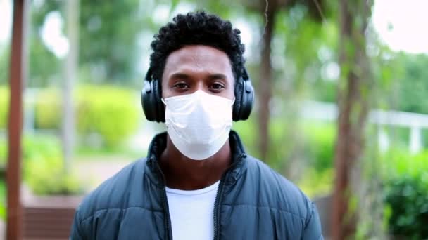 African Man Listening Music Headphone While Wearing Covid Surgical Mask — Vídeo de Stock