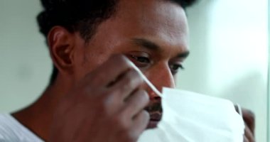 African american man putting covid mask, black person puts on virus prevention mask