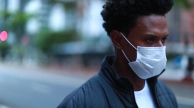 Black African person walking in city wearing surgical mask prevention against virus
