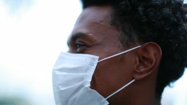 African black man wearing covid mask looking to camera smiling portrait
