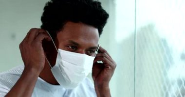 Black man putting on preventive mask during pandemic