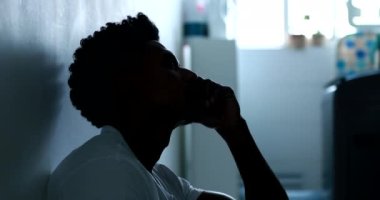 Person feeling emotional pain and suffering sitting on floor with heads on head thinking
