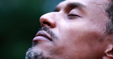Person close-up face opening eyes to sky and smiling