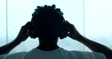 Man putting on headphone listening to music