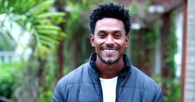 Confident black man portrait smiling to camera. African person walking forward