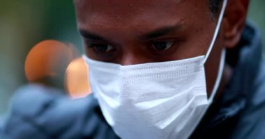 Young black african man wearing face mask outside. close-up