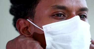 Black African man removing virus mask and smiling to camera portrait