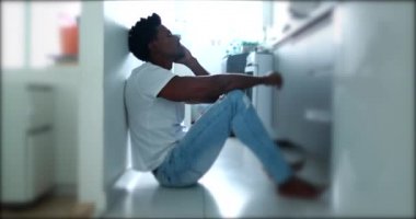 Black african man sitting on floor praying for divine help, asking for god guidance during crisis