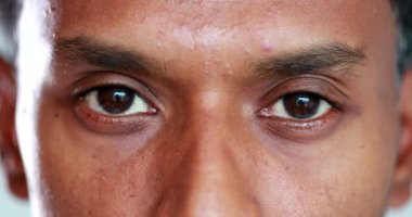 Close-up face african descent closing and opening eyes, smiling reaction