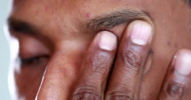 Tired man rubbbing eye with hand. Exhausted african american touching face