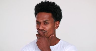 Pensive African American man portrait looking to camera deciding. Thoughtful black guy pondering decision