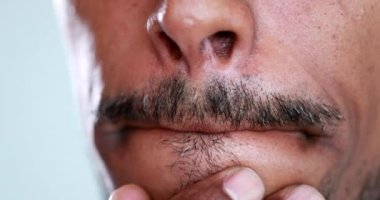 Person touching mouth thinking, macro close-up african descent, pandemic concept dont touch your face