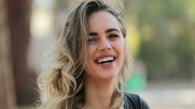 Hispanic latin girl looking to camera laughing outdoors