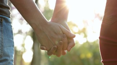 Hands held together with sunlight flare in the background