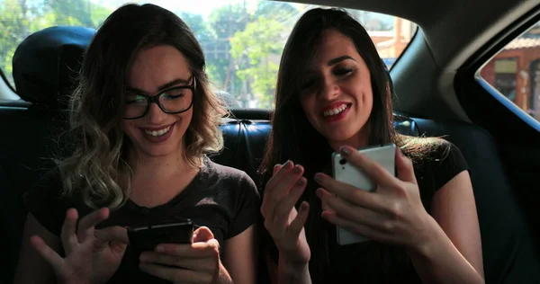 Women Friends Using Cellphone Back Seat Car —  Fotos de Stock