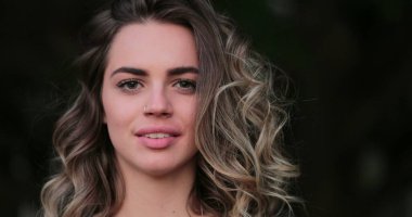 Flirtatious beautiful blonde hispanic young woman looking to camera smiling