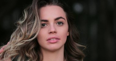 Flirtatious beautiful blonde hispanic young woman looking to camera smiling