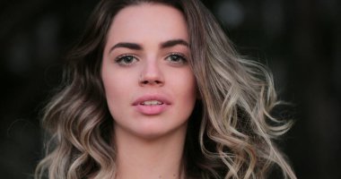 Flirtatious beautiful blonde hispanic young woman looking to camera smiling