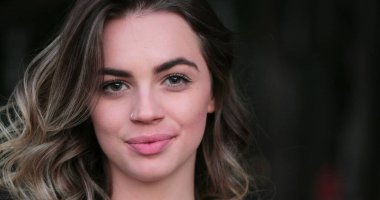 Flirtatious beautiful blonde hispanic young woman looking to camera smiling