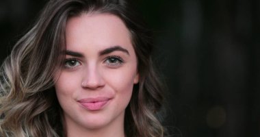 Flirtatious beautiful blonde hispanic young woman looking to camera smiling