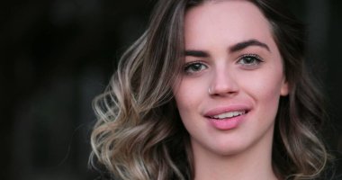 Flirtatious beautiful blonde hispanic young woman looking to camera smiling