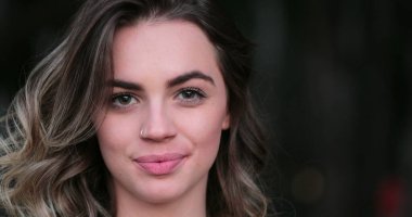 Flirtatious beautiful blonde hispanic young woman looking to camera smiling