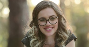 Beautiful hispanic student girl smiling to camera. Portrait of happy latina young woman wearing glasses looking to viewer