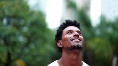 Man looking to the sky feeling hopeful outdoors