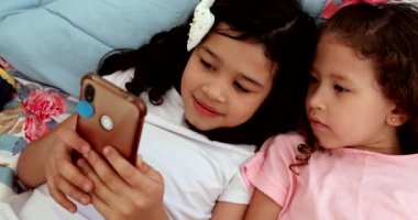Pre-teen little girls in front of smartphone device, social media addiction in children