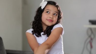 Pensive little hispanic girl child having an eureka moment idea