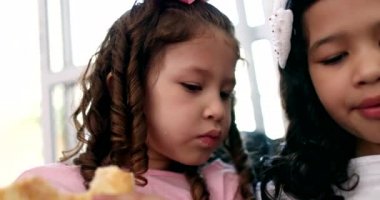 Two little girls eating sandwiches, children afternoon snack
