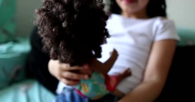 Hispanic little girl child playing with black doll