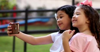 Children taking selfie with cellphone, pre-teen girls take selfie