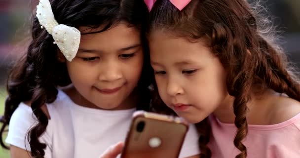 Дети Смотрят Мобильное Устройство Две Маленькие Девочки Просматривают Интернет Смартфоне — стоковое видео