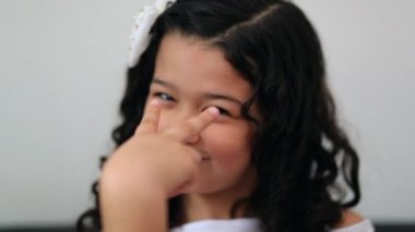 Hispanic child girl making watching you gesture by pointing eye with finger