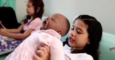 Mix race little girl child hugging black baby doll